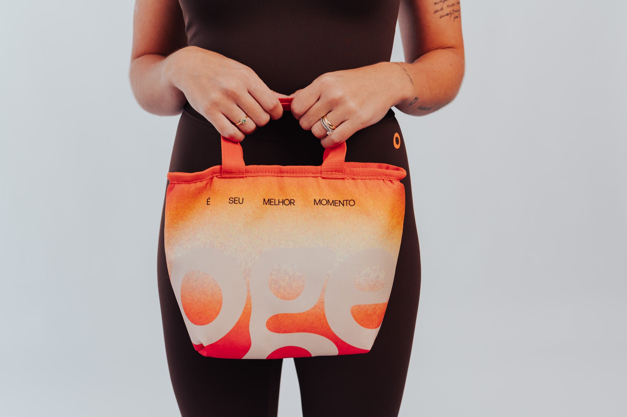 Bolsa Térmica OGE laranja, segurada à frente do corpo