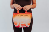 Bolsa Térmica OGE laranja, segurada à frente do corpo